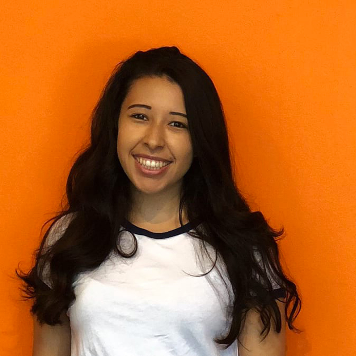 Jeannette Martinez in front of an orange background.